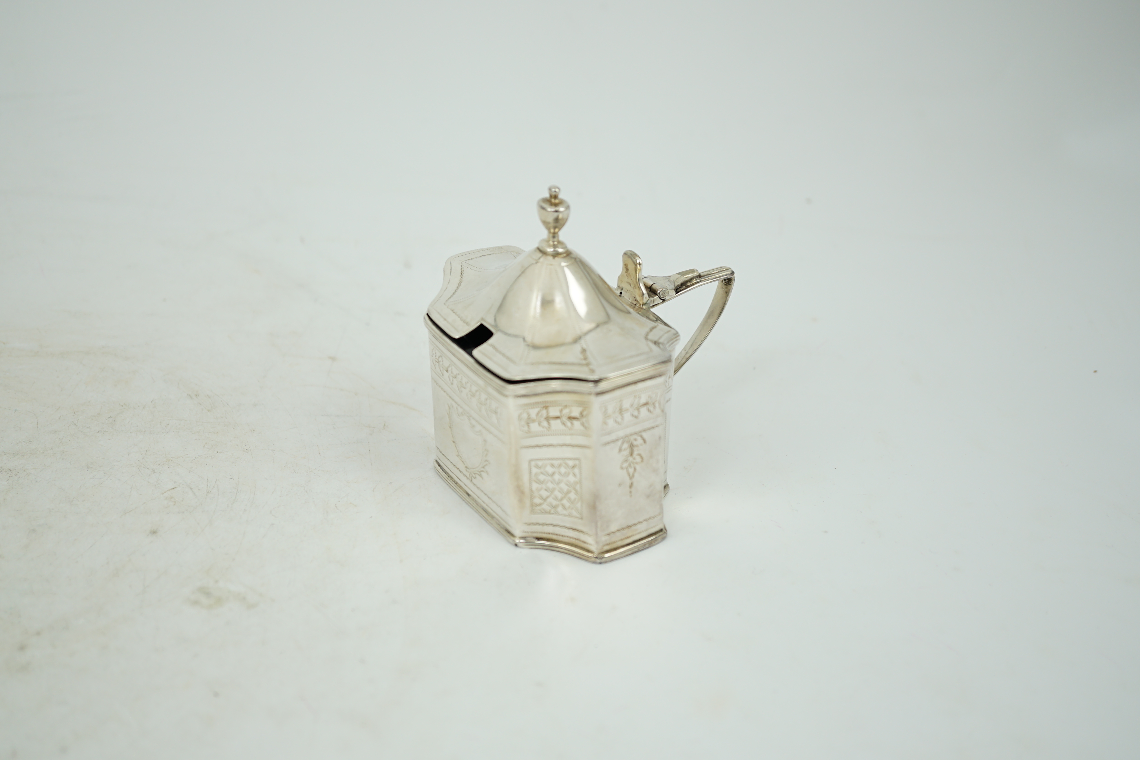 A George III silver mustard pot, with inverted angles and blue glass liner, Alexander Field, London, 1803, height 85mm.